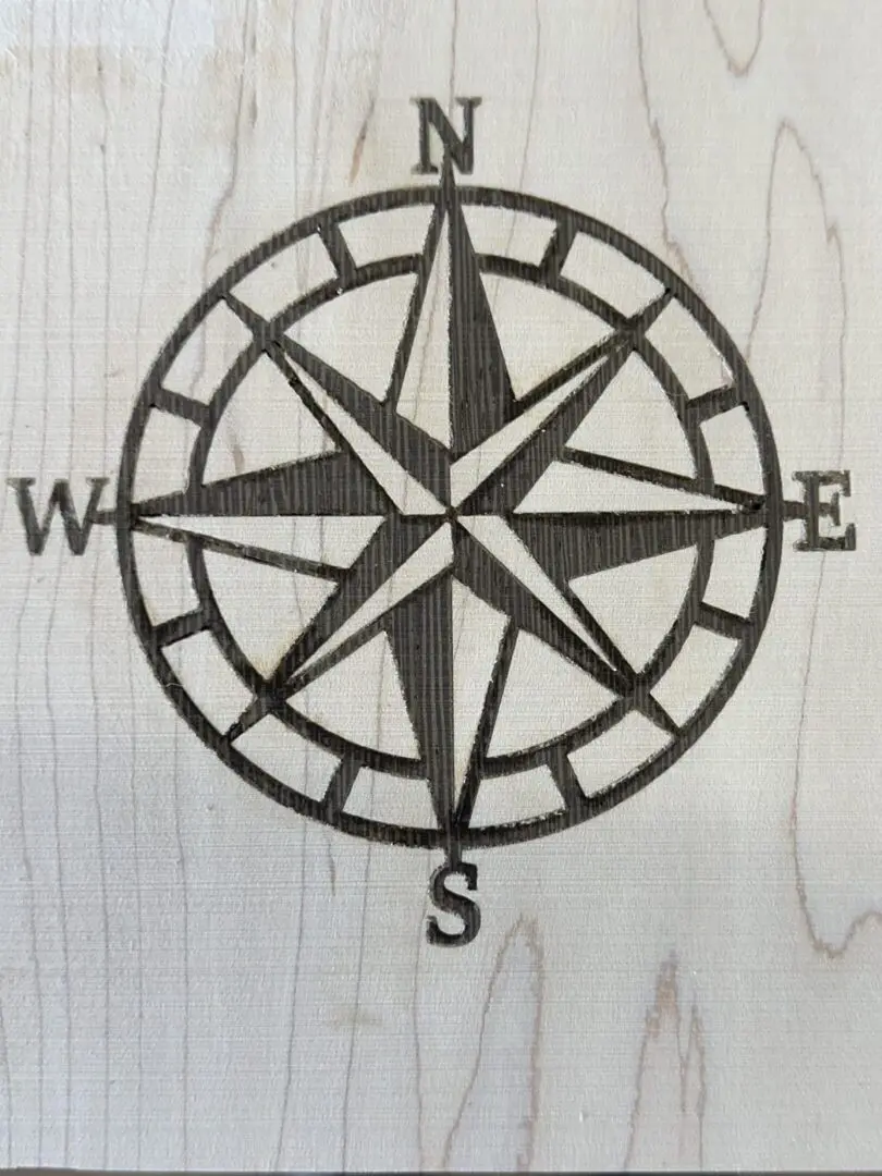 Laser-etched compass rose on light wood