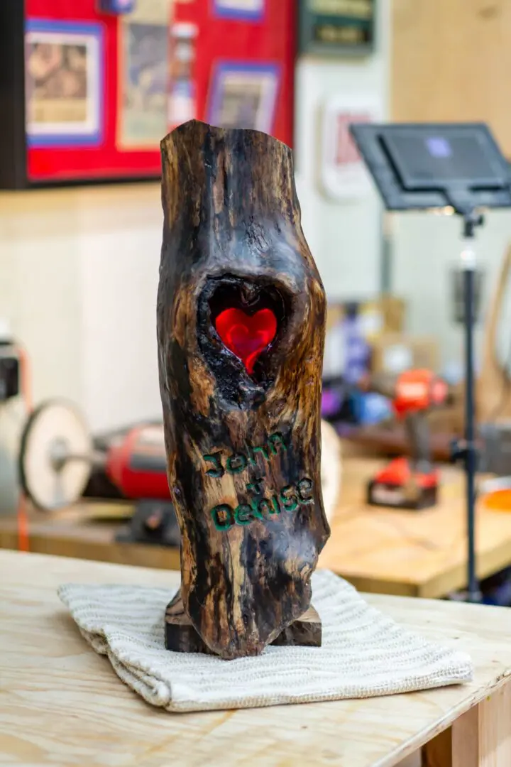 Carved wooden log sculpture with red heart