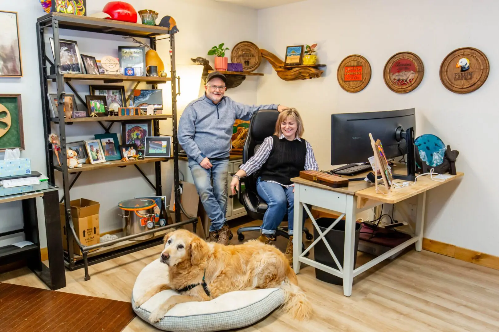 Smiling couple and golden retriever in office