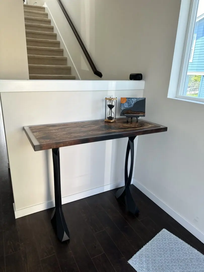 Wooden console table by staircase and window